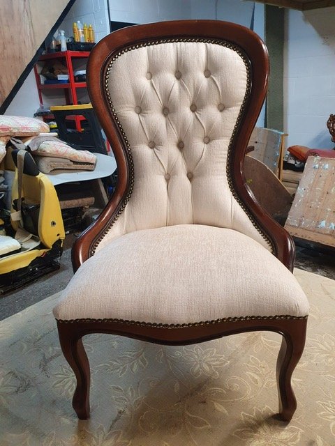 Upholstery repair specialist restoring armchair